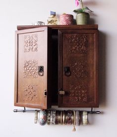 a wooden cabinet sitting on top of a wall