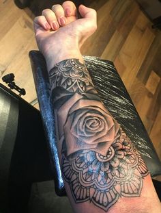 a woman's arm with a rose tattoo on it and an arrow in the middle