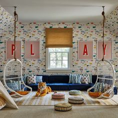 a living room with two hanging chairs and a cat on the floor in front of it