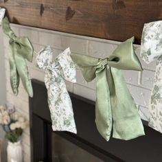 some green bows are hanging from a mantle