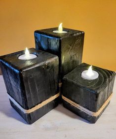 three black square candles sitting next to each other