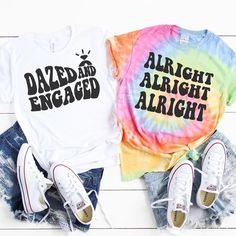 two t - shirts with the words dazed engaged and alright are sitting next to each other