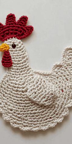 a crocheted chicken with a red and white comb on it's head