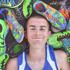 a young man is surrounded by running shoes