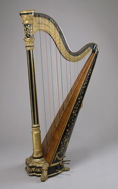 an ornate gold and black harp on a gray background