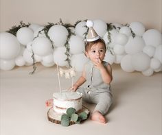 a baby is sitting in front of a cake