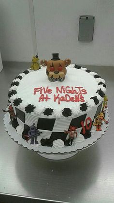 a five nights at madison cake on display in a room with silver counter top and white walls