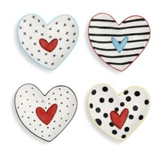 four heart shaped cookies with black and white stripes, red hearts, and polka dots