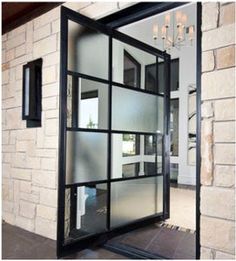 an open glass door in front of a brick wall with chandelier hanging from the ceiling