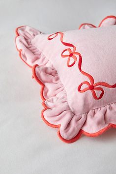 a pink and red pillow with ruffled edges