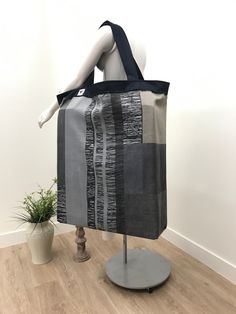 a mannequin wearing a black and white bag on top of a wooden floor