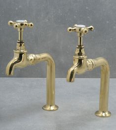 two brass faucets with handles on each side, one is turned to the right