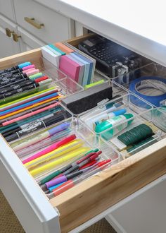 the drawers are filled with pens, markers and other office supplies