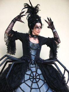 a woman in a black and blue dress with large spider webs on her arms