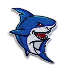 a blue and white shark with teeth on it's face, embroidered onto the back of