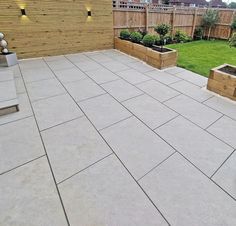 an outdoor patio with raised planters and wooden fence