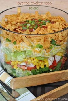 a glass bowl filled with salad and chips