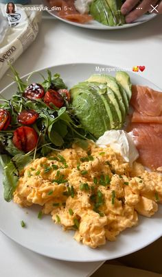 eggs, avocado and tomatoes on a plate with other foods in the background