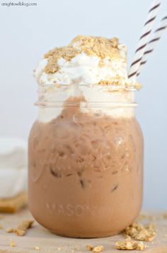 a glass jar filled with chocolate pudding and whipped cream topped with graham cracker crumbs