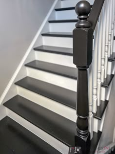 a black and white stair rail next to a set of stairs with balusters