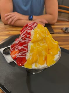 a person sitting at a table with a plate of food in the shape of fruit