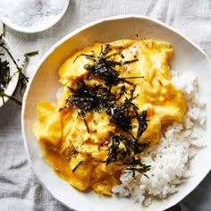 a white bowl filled with rice and some kind of food on top of a table