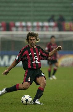 a man kicking a soccer ball on top of a field