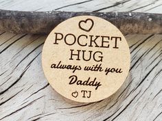 a wooden coaster with the words pocket hug always with you daddy on it sitting on a piece of wood