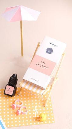 an open book sitting on top of a table next to a pink and white umbrella