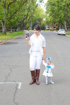 a woman and child dressed in white are walking down the street