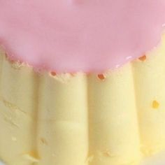 a pink and yellow dessert sitting on top of a white plate