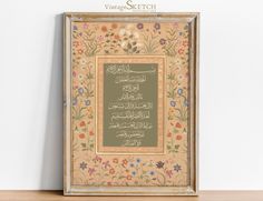 an ornate frame with arabic writing and flowers on the border is displayed in front of a white wall