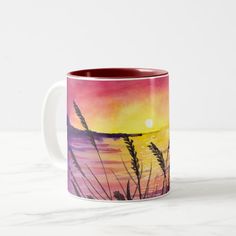 watercolor painting of sunset over the ocean with reeds on it two - tone coffee mug