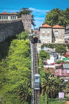 an aerial view of a train going down the tracks in front of some old buildings