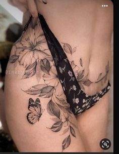 a woman's stomach with flowers and butterflies on it, as well as a tie