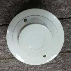 an overhead view of a white round object on the ground with screws in it