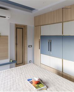 a bed room with a neatly made bed and cupboards on the wall next to it