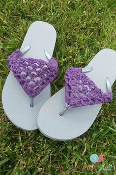 a pair of purple crocheted flip flops laying on top of green grass