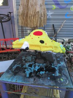 a crocheted pikachu hat sitting on top of an old metal table