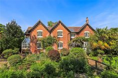 a large red brick house surrounded by greenery