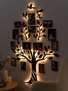 a living room filled with furniture and framed pictures on the wall next to a tree