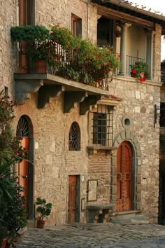 an old stone building with flowers on the balconies