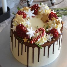 a white cake with chocolate icing, candy canes and stars on top is sitting on a plate