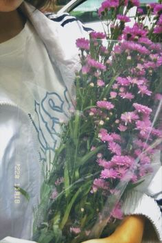 a woman holding a bunch of flowers in her hands