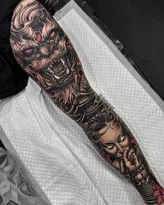 a man's arm with tattoos on it and an image of a demon in the background