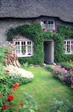 a house with flowers and plants around it