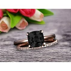 an engagement ring and wedding band set with a cushion cut black diamond in the center