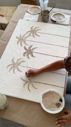 a person painting on a table with white paint