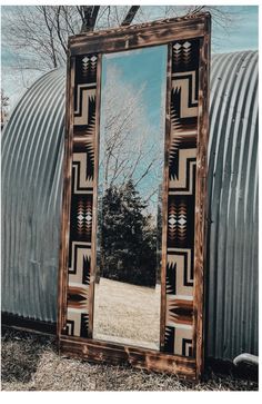 a large mirror sitting on top of a grass covered field