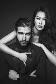 a man and woman are posing for a black and white photo with their arms around each other